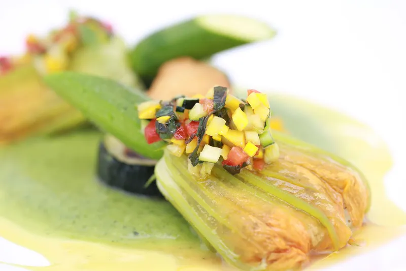 Fleurs de courgettes farcies d'une mousseline aux herbes, tartare de courgette, curry citron